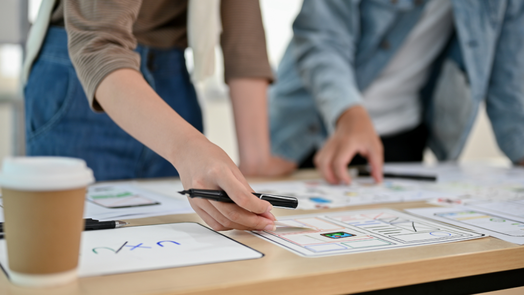 Two young UX designers collaborating to enhance a client's website design and UX.